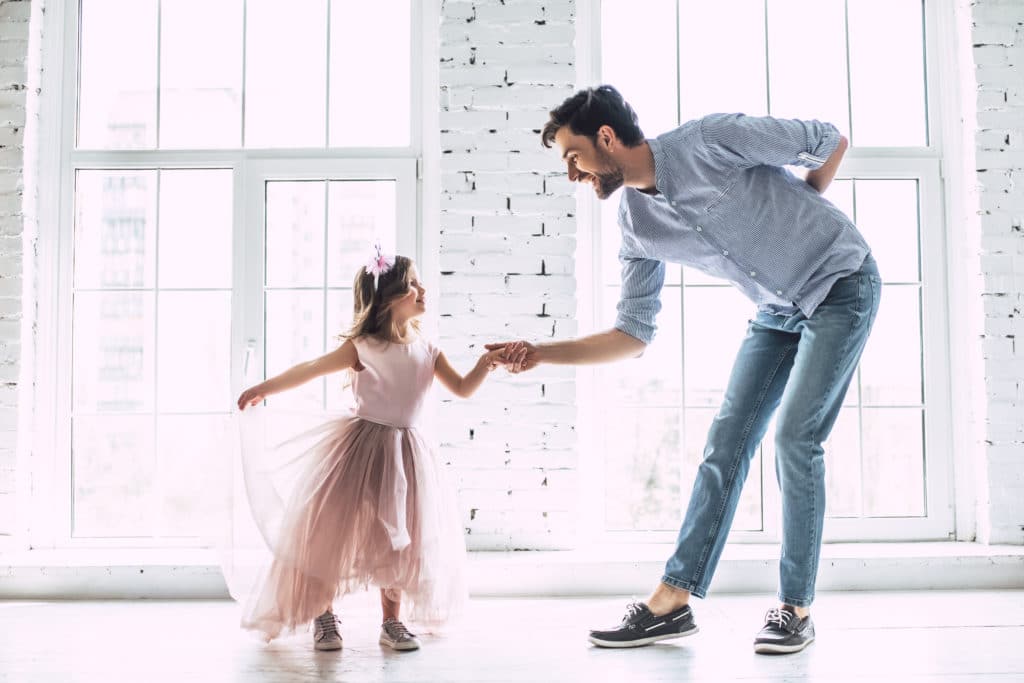 young girl dancing with her dad